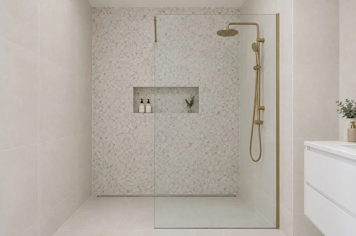 Walk-in shower with a single fixed glass panel and terrazzo-look tiles