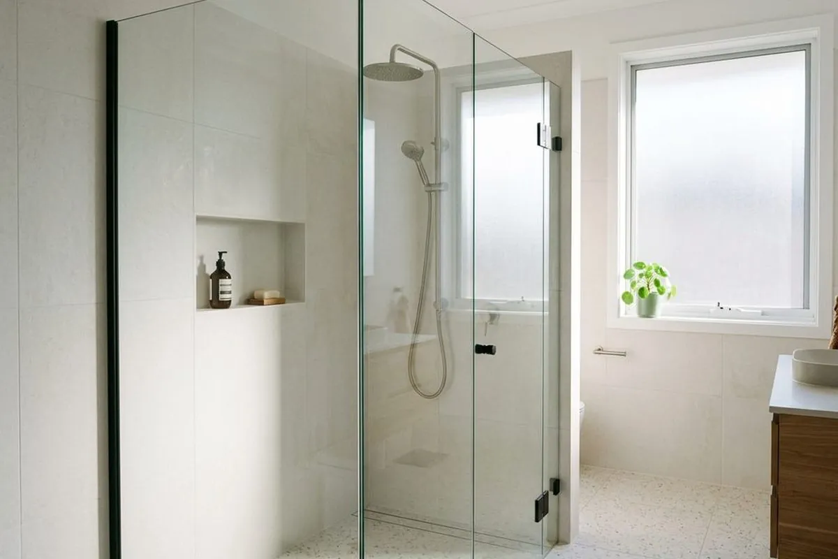 After: a frameless clear shower screen in the same bathroom